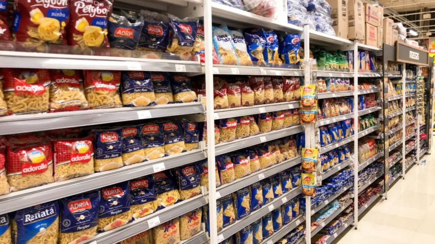 corredor de supermercado com alimentos; mudança no PIS e Cofins é criticada pelo setor alimentício