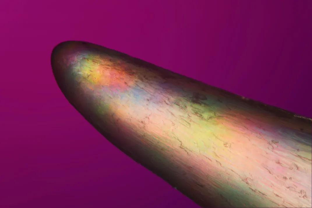 Острый заостренный предмет с переливающимися цветами.