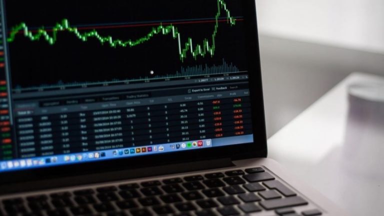Acima, imagem baixada de um site de fotos gratuitas mostra um computador aberto com ações de mercado na tela