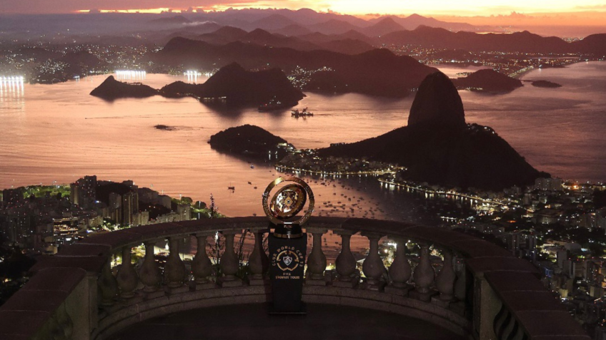 na imagem, a taça do Mundial de clubes de 2025 em um dos cartões postais do Rio de Janeiro