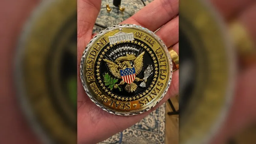 Flávio Bolsonaro publicou imagem da challenge coin entregue por Donald Trump na Casa Branca